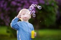 Cute little boy blowing soap bubbles in park Royalty Free Stock Photo