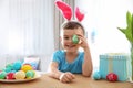 Cute little boy with bunny ears headband playing with painted Easter egg Royalty Free Stock Photo