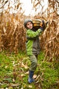 Cute little boy carrying a big pumpkin