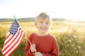 Cute little boy celebrating of July, 4 Independence Day of USA at sunny summer sunset. Child running with american flag symbol of Royalty Free Stock Photo