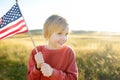 Cute little boy celebrating of July, 4 Independence Day of USA at sunny summer sunset. Child running and jumping with american Royalty Free Stock Photo