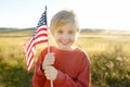 Cute little boy celebrating of July, 4 Independence Day of USA at sunny summer sunset. Happy child running and jumping with Royalty Free Stock Photo