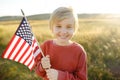 Cute little boy celebrating of July, 4 Independence Day of USA at sunny summer sunset. Happy child running and jumping with Royalty Free Stock Photo