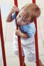 Cute little boy climbing through fence Royalty Free Stock Photo
