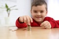 Cute little boy with coins at home. Counting money Royalty Free Stock Photo