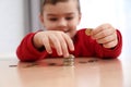 Cute little boy with coins at home. Counting money Royalty Free Stock Photo