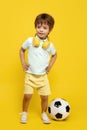 Cute little boy dance over yellow background. Headphones. Soccer Ball. Royalty Free Stock Photo