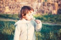 Cute little boy with dandelions outdoors at sunset. Royalty Free Stock Photo
