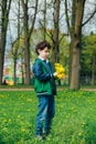 Cute little boy with dandelions in park on warm spring day, Royalty Free Stock Photo