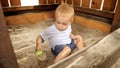 Cute little boy digging sand with toy shovel in sandbox at park. Kids playing outdoors, children having fun, summer vacation and Royalty Free Stock Photo