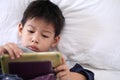 Cute little boy with digital tablet, early learning.asian boy playing game on the bedroom.