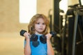 Cute little boy doing exercises with dumbbells. Portrait of sporty child with dumbbells. Happy child boy exercising Royalty Free Stock Photo
