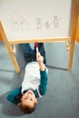 Cute little boy drawing on white board with felt pen and smiling Royalty Free Stock Photo