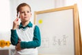 Cute little boy drawing on white board with felt pen and smiling Royalty Free Stock Photo