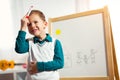 Cute little boy drawing on white board with felt pen and smiling Royalty Free Stock Photo