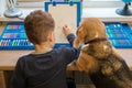 Cute little boy draws with felt-tip pens sitting at the table