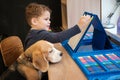 Cute little boy draws with felt-tip pens sitting at the table