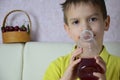 Cute little boy drinking juice at home, cherry juice drinks from a bottle or a glass with a straw. Royalty Free Stock Photo