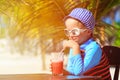 Cute little boy drinking juice on tropical beach Royalty Free Stock Photo