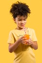 Cute little boy drinking orange juice with a straw Royalty Free Stock Photo