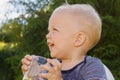 Cute little boy drinkng a glass of fresh water. Funny laughing toddler