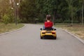 Cute little boy driving children`s car outdoors, back view. Space for text Royalty Free Stock Photo