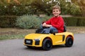 Cute little boy driving children`s car outdoors Royalty Free Stock Photo