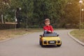 Cute little boy driving children`s car outdoors. Space for text Royalty Free Stock Photo