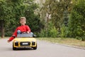 Cute little boy driving children`s car outdoors. Space for text Royalty Free Stock Photo