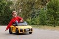 Cute little boy driving children`s car outdoors. Space for text Royalty Free Stock Photo