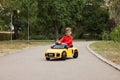 Cute little boy driving children`s car outdoors. Space for text Royalty Free Stock Photo