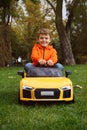 Cute little boy driving children`s car in park Royalty Free Stock Photo