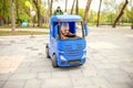 Cute little boy driving electric toy car outdoors in park. Royalty Free Stock Photo