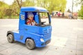 Cute little boy driving electric toy car outdoors in park. Royalty Free Stock Photo