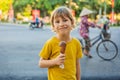 Cute little boy, eating big ice cream in the park, smiling at camera, summertime Royalty Free Stock Photo