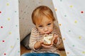 Cute little boy eating bread and butter in a hut, looking up at a camera Royalty Free Stock Photo