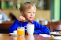 Cute little boy eating breakfast in cafe Royalty Free Stock Photo