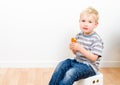 Cute little boy eating delicious cookie at home