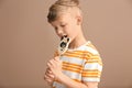 Cute little boy eating lollipop on color background Royalty Free Stock Photo