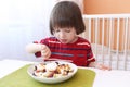 Cute little boy eats fruit salad