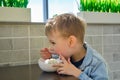 Cute little boy enjoying ice cream in cafe Royalty Free Stock Photo
