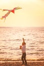 Cute little boy flying kite near river at sunset Royalty Free Stock Photo