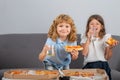 Cute little boy and girl eating Pizza at home. Children holding a slices of pizza on party at home. Little girl and boy Royalty Free Stock Photo