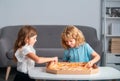 Cute little boy and girl eating Pizza at home. Children holding a slices of pizza on party at home. Children sharing a Royalty Free Stock Photo