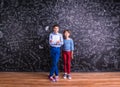 Cute little boy and girl in front of a big blackboard. Royalty Free Stock Photo