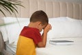 Cute little boy with hands clasped together saying bedtime prayer over Bible at home. Space for text Royalty Free Stock Photo