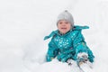 Cute little boy happily playing in the white fluffy fresh snow outdoors in winter Royalty Free Stock Photo