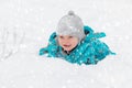 Cute little boy happily playing in the white fluffy fresh snow outdoors in winter. Royalty Free Stock Photo