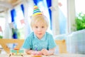 Cute little boy having fun and celebrate birthday party with colorful decoration and cake