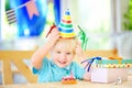 Cute little boy having fun and celebrate birthday party with colorful decoration and cake